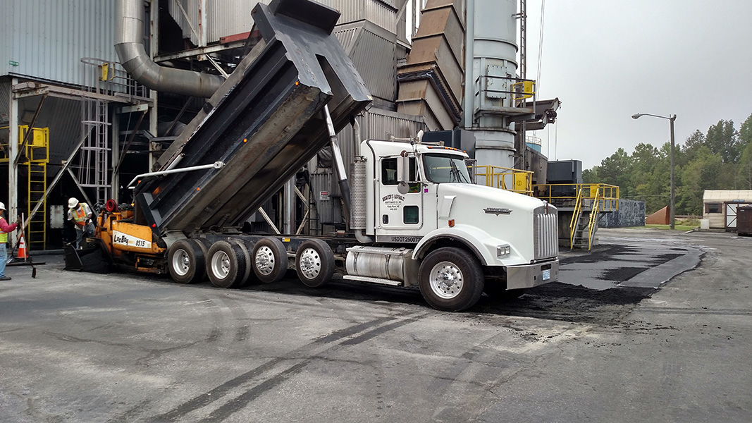 Weavers Asphalt dump truck pouring out asphalt